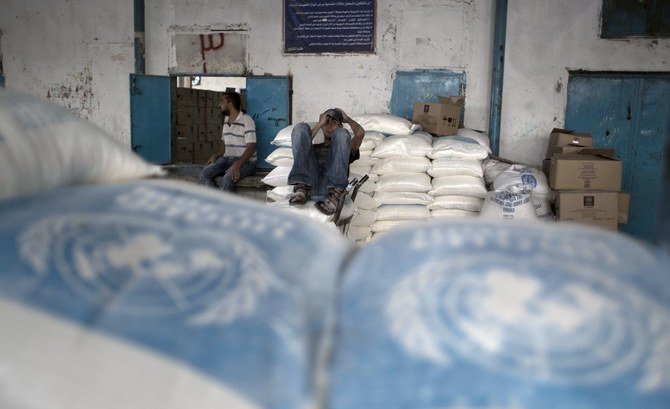 Palestinian men rest at an aid distribution centre of UNRWA in Rafah in the southern Gaza Strip. (File/AFP)