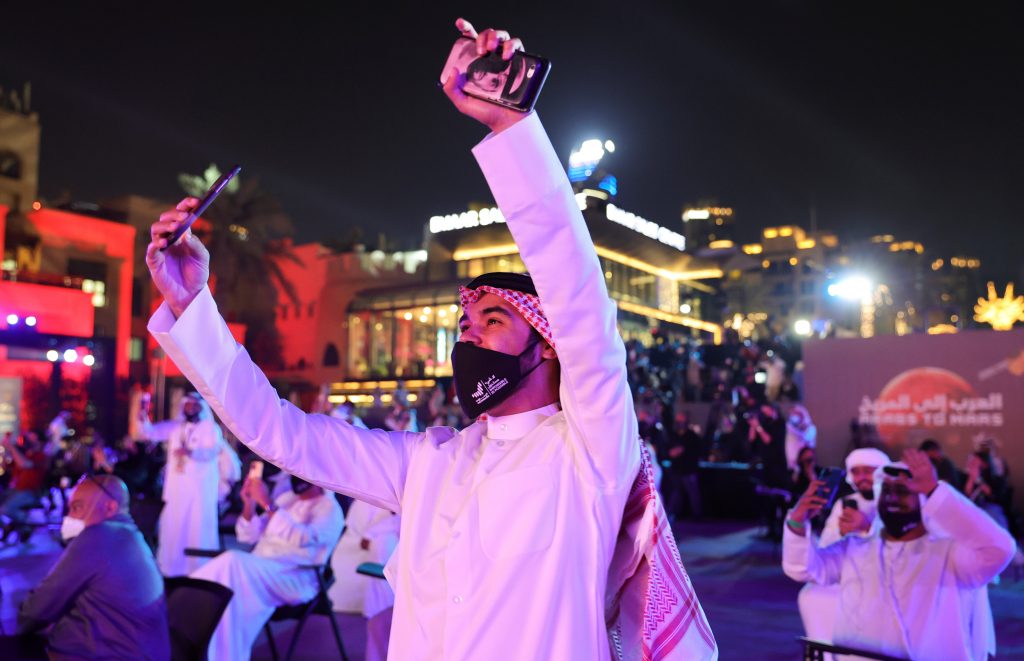 People react as they watch screens displaying information of the Hope Probe entering the orbit of Mars, in Dubai, United Arab Emirates, February 9, 2021. REUTERS/Christopher Pike