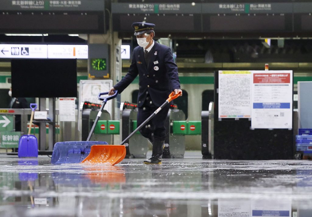 A worker scoops out water following an earthquake inside Fukushima station in Fukushima, northeastern Japan, Feb. 14, 2021. (File photo/Kyodo News via AP)