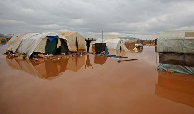 A Syrian man reacts as water floods tents at a camp for the internally displaced near the town of Kafr Lusin in the rebel-held northwestern province of Idlib, by the border with Turkey, on Jan. 19, 2021. (AFP)