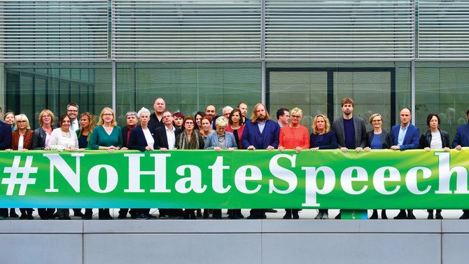 Members of Germany’s Greens party parliamentary group pose behind a banner against hate speech; experts says legislators have failed to keep pace with technological change when tackling with question of social media and free speech. AFP