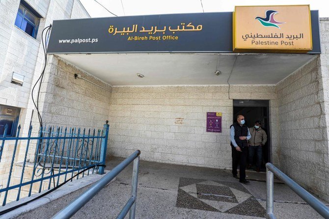 A man walks out of a post office in the city of al-Bireh, about 15 kilometres north of Jerusalem in the occupied West Bank, on February 7, 2021. (AFP)