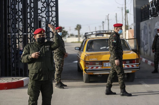 Members of the Palestinian security forces loyal to Hamas, mask-clad due to the coronavirus pandemic, stand guard at the Rafah border crossing with Egypt, in the southern Gaza Strip, on Feb. 9, 2021. (File/AFP)