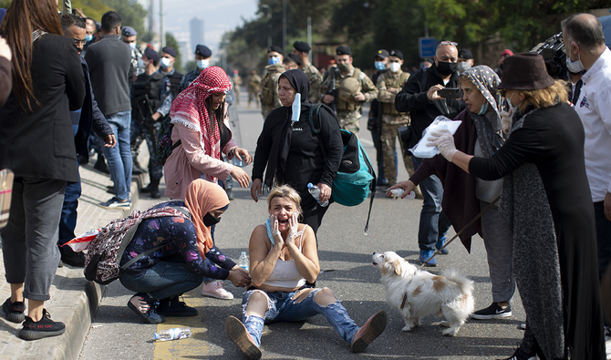 A protester reacts as riot police and army soldiers scuffle with anti-government protesters outside a military court, in Beirut, Lebanon. (AP)