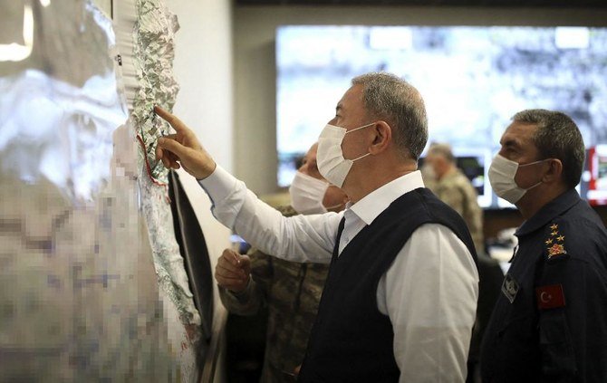 Above, Turkish Minister of Defense Hulusi Akar looks at a map at the Army Command Control Center in Ankara during the military operation dubbed Claw-Tiger on June 17, 2020 against Kurdish rebels in northern Iraq. (Turkish Defense Ministry/AFP)