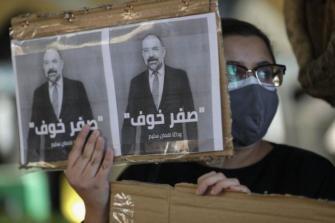 Activists display placards bearing the portrait of slain prominent activist Luqman Slim and the Arabic slogan ‘zero fear’ at a demonstration in downtown Beirut on Feb. 9, 2021. (AFP)