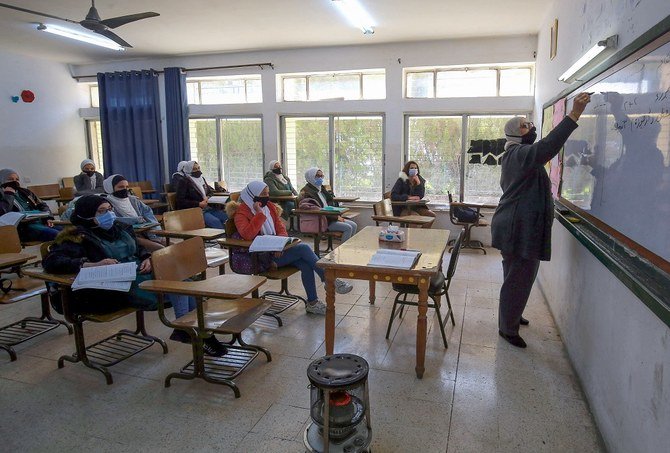 Jordanian pupils wearing protective face masks attend class for the first time in nearly a year in Amman on Feb. 7, 2021. (AFP)