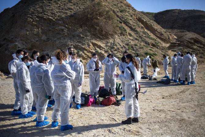 Israeli soldiers wearing protective suits listen to a briefing ahead of cleanup operations to remove tar from a beach after an oil spill in the Mediterranean Sea At Sharon Beach Nature Reserve, near Gaash, Israel, Feb. 22, 2021. (AP)