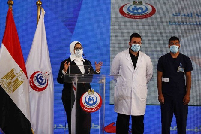 (L to R) Egyptian Health Minister Hala Zayed gives a press conference, accompanied by doctor Abdelmouim Selem and medical staff member Ahmed Hemdan, in a tent set up outside the Abou Khalifa hospital, in Ismailia, about 120kms east the capital Cairo, on Jan. 24, 2021, after the two men received a dose of a coronavirus vaccine. (File/AFP)