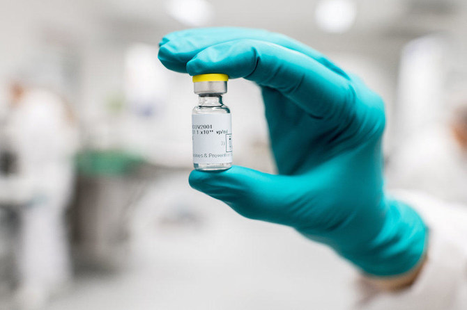 A lab worker holds a vial of Johnson & Johnson's Janssen coronavirus disease (COVID-19) vaccine candidate in an undated photograph. (Johnson & Johnson/Handout via REUTERS)