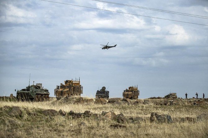 A Russian Mil Mi-24 Hind helicopter gunship flies over a joint Russian and Turkish convoy as it patrolls in oil fields near the town of al-Qahtaniyah, in Syria’s northeastern Hasakeh province close to the Turkish border, on Feb. 4, 2021. (File/AFP)