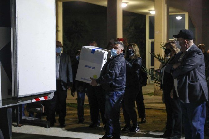 Members of staff unload boxes of the first shipment of the COVID-19 Pfizer-BioNTech vaccine upon arrival to the Rafik Hariri University Hospital in the Lebanese capital Beirut, on February 13, 2021. (AFP)