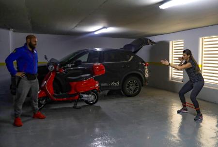 Lebanese trap shooter Ray Bassil works with her cousin and temporary trainer in the underground parking of her building. (AFP)