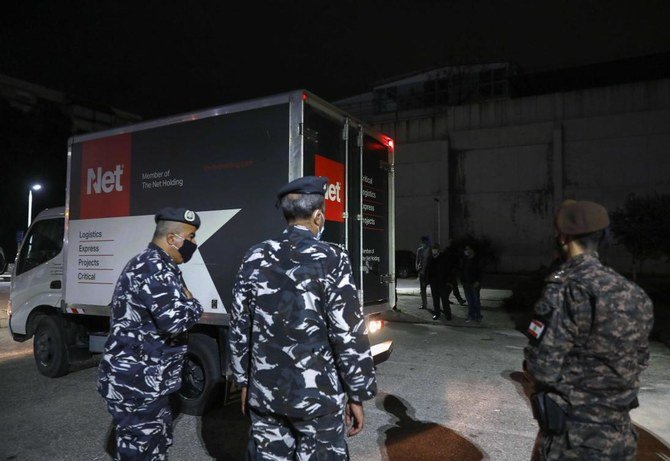 Members of Lebanese security forces stand next to a truck transporting boxes of the first shipment of the COVID-19 Pfizer-BioNTech vaccine, upon arrival to the Rafik Hariri University Hospital in the capital Beirut, on February 13, 2021. (AFP)