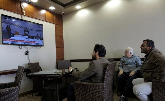 Men watch the elections to choose the new interim government on a TV screen at a cafe in Benghazi, Libya February 5, 2021. (Reuters)