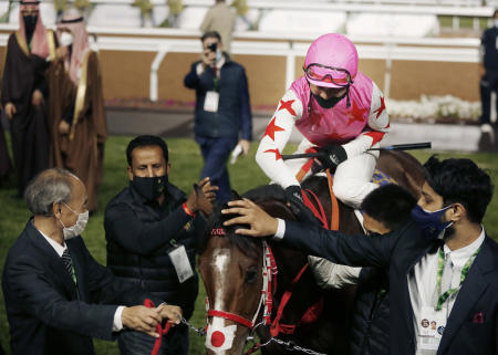 Japanese jockey Keita Tosaki greets his horse Pink Kamehameha after he wins the ¥158 million Japanese yen ($1.5 million) Saudi Derby competition of the Saudi Cup, at King Abdul Aziz race track in Riyadh, Saudi Arabia, Saturday, Feb. 20, 2021. (AP)
