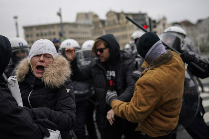 Protesters scuffle with anti riot policemen during an unauthorised demonstration against COVID-19 restrictive measures in Brussels, Sunday, Jan. 31, 2021. (AP)