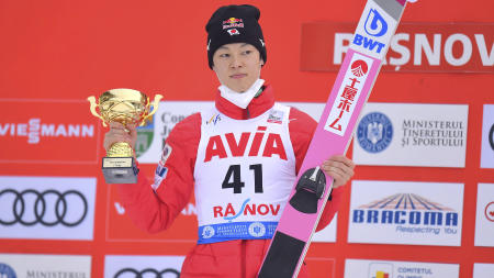 Japan's Ryoyu Kobayashi stands on the podium after winning first place at the men's Ski Jumping World Cup event in Rasnov, Romania, Friday, Feb. 19, 2021. (AP)