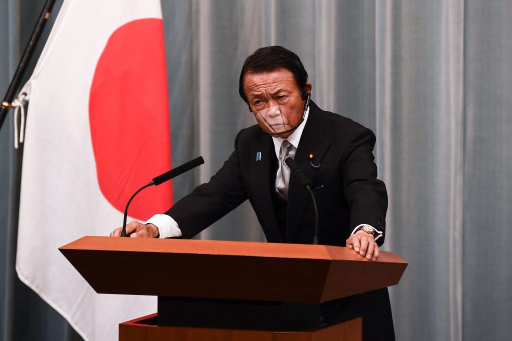 Finance Minister Taro Aso said it was hard to revitalise the economy with monetary easing alone, calling on companies to help out by raising salaries for employees. (AFP)