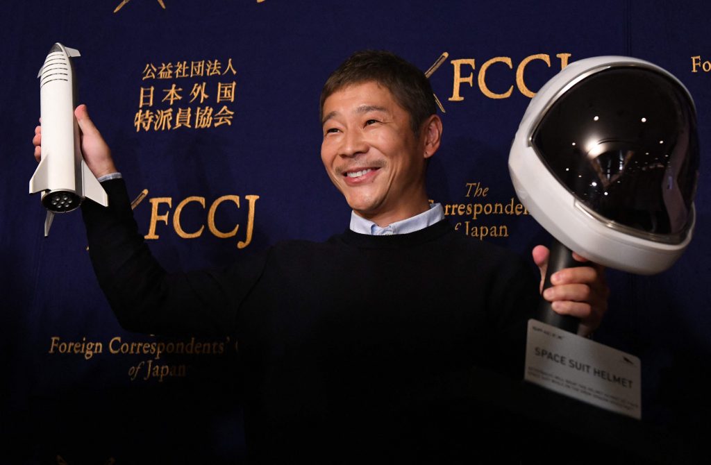 This file photo taken on October 9, 2018 shows Japanese billionaire Yusaku Maezawa, the first private passenger who will fly around the Moon aboard the SpaceX BFR launch vehicle, posing with a model rocket and space helmet prior to a press conference in Tokyo. (AFP)