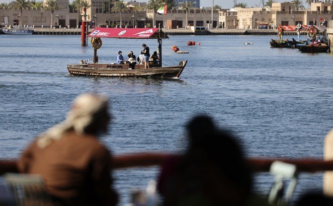 Emiratis look on as a boat carrying tourists sails at the Ras El-Khor wildlife sanctuary near the old quarter of the Gulf city of Dubai, on January 6, 2021. (File/AFP)