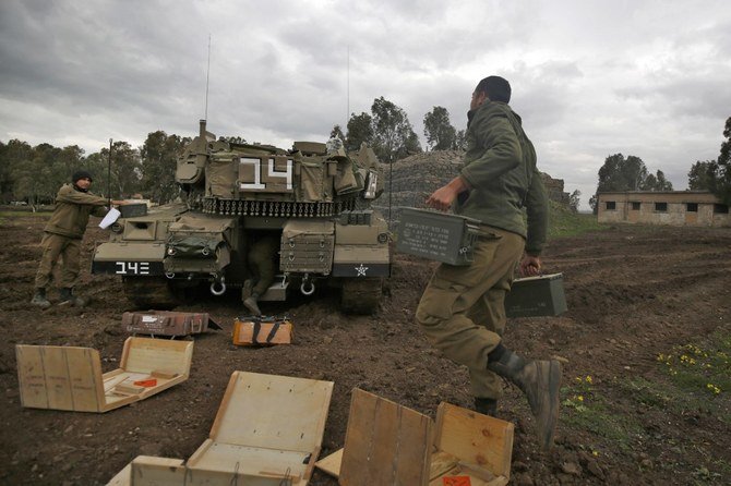 Israeli soldiers supply a Merkava Mark 4 battle tank, near the Syrian border in the Israeli-annexed Golan Heights, on Feb. 4, 2021. (File/AFP)