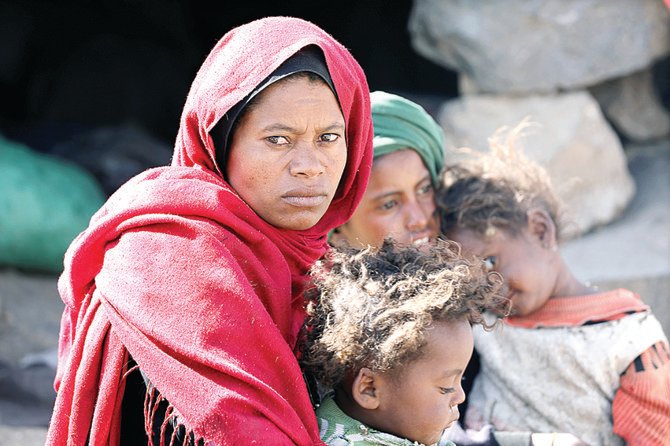 A woman sits with her children at a camp for internally displaced people on the outskirts of Houthi-occupied Sanaa as Iran-backed militias continue their attacks. (Reuters)