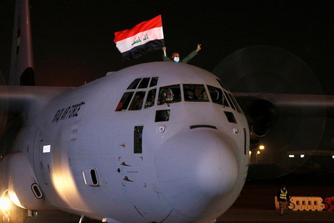 A man waves the Iraqi flag from an aircraft carrying the first batch of doses of the Sinopharm vaccine against the coronavirus disease (COVID-19) after it arrived at Baghdad International Airport, in Baghdad, Iraq, March 2, 2021. (Reuters)