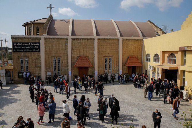 Christian families gather outside St. George Chaldean Church as they wait for the arrival of Pope Francis in Baghdad on March 5, 2021. (Reuters)