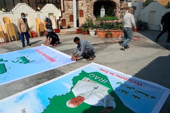 Iraqi Christians prepare posters welcoming Pope Francis to St. Joseph’s Chaldean Church in Baghdad on March 2, 2021. (AP)