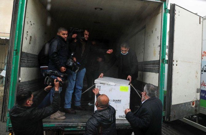 File photo shows Palestinians unloading a batch of the first shipment of the coronavirus disease vaccines, in Gaza City Feb. 17, 2021. (Reuters)