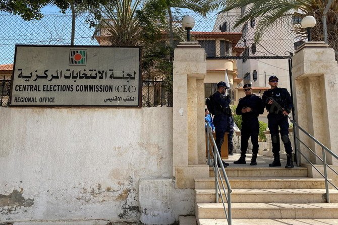 Police officers stand guard as Palestinians begin registering party lists for May parliamentary election, at the Central Elections Commission's office in Gaza City March 20, 2021. (Reuters)