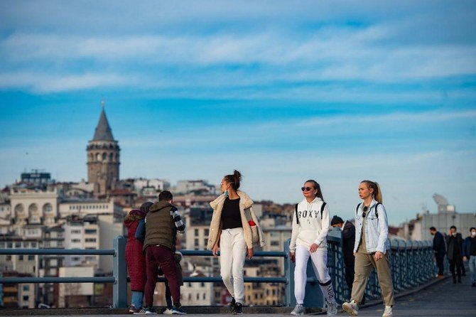 Tourists walk near Galata bridge during a two-day curfew to limit the spread of the Covid-19 disease in Istanbul. (File/AFP)