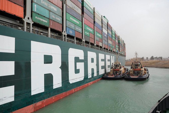 Two tugboats are seen near the Ever Given, which has become wedged across the Suez Canal and blocking traffic in the vital waterway from another vessel. (Suez Canal Authority via AP)