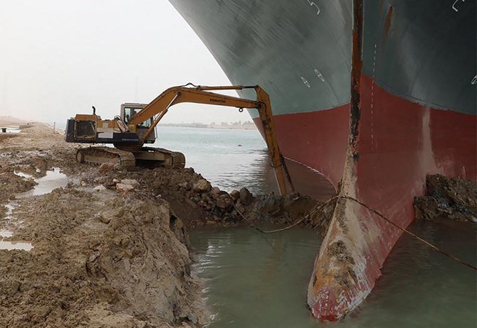 A backhoe digs out the keel of the Ever Given argo ship that is wedged across the Suez Canal and blocking traffic in the vital waterway. (Suez Canal Authority via AP)