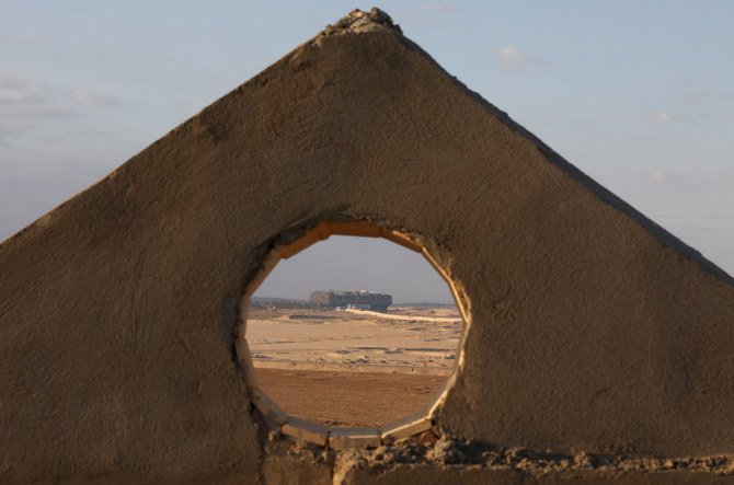 The stranded container ship Ever Given, which ran aground in Suez Canal, Egypt, is seen through a whole in a wall on March 28, 2021. (REUTERS/Mohamed Abd El Ghany)