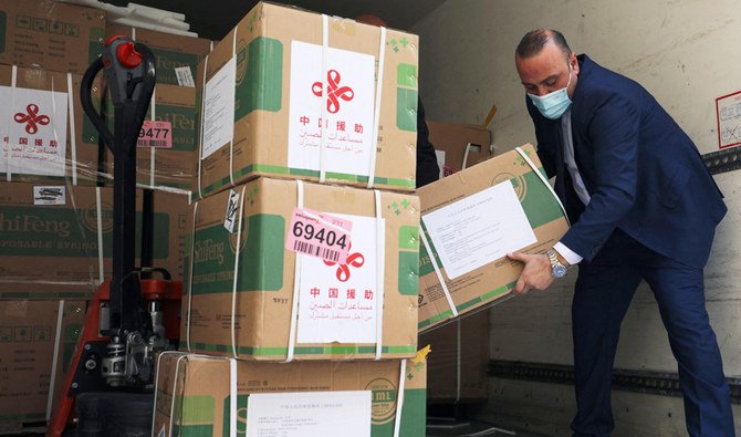 Staff members of the Palestinian Ministry of Health unload a shipment of the Sinopharm COVID-19 vaccines donated by the Chinese government in the city of Ramallah in the West Bank, on March 29, 2021. (AFP)