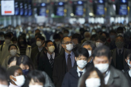A station passageway is crowded with commuters wearing face masks during a rush hour at Shinagawa Station Monday, March 22, 2021, in Tokyo. (AP)