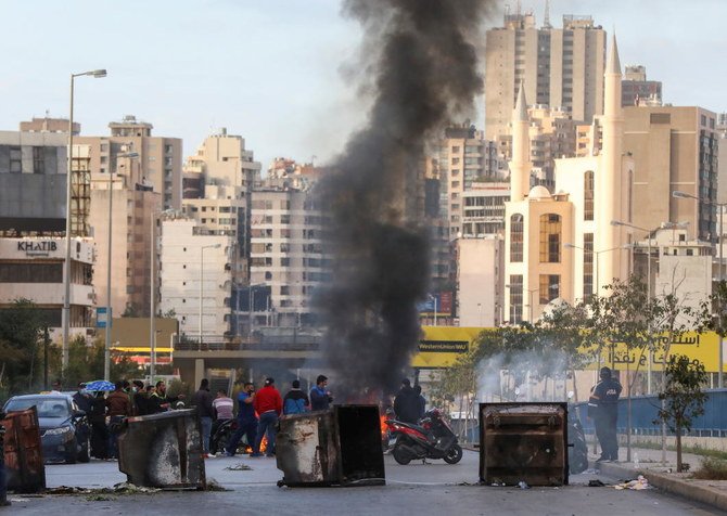 Demonstrators block a road with garbage bins, during a protest against the fall in Lebanese pound currency and mounting economic hardships, in Beirut, Lebanon March 16, 2021. (Reuters)