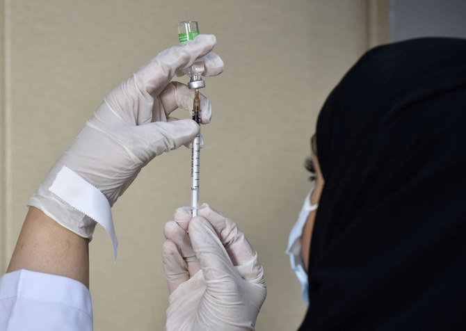A medical worker prepares a dose of the AstraZeneca COVID-19 vaccine at the first drive-through vaccination center in the Saudi capital Riyadh, on March 4, 2021. (AFP)