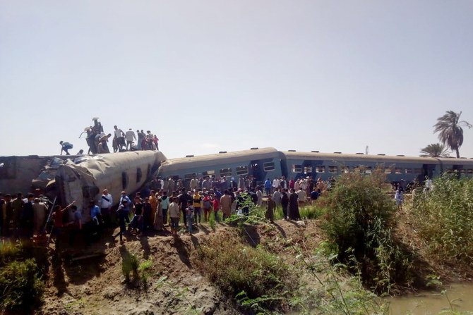 People inspect the damage after two trains have collided near the city of Sohag, Egypt, March 26, 2021. (Reuters)