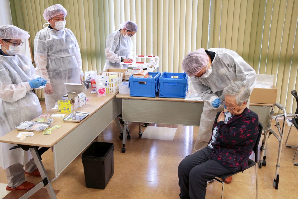 An elderly woman receives a dose of the Covid-19 vaccine in Setagaya district of Tokyo, as Japan begins vaccinating the elderly, April. 12, 2021. (AFP)