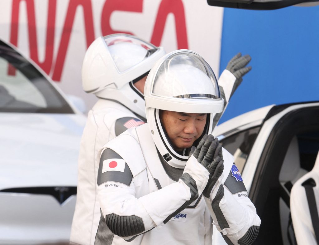 Japan Aerospace Exploration Agency (JAXA) astronaut Soichi Noguchi (R) and NASA astronaut Mike Hopkins wave to family members after walking out of the Operations and Checkout Building on their way to the SpaceX Falcon 9 rocket with the Crew Dragon spacecraft on launch pad 39A at the Kennedy Space Center on November 15, 2020. (AFP)