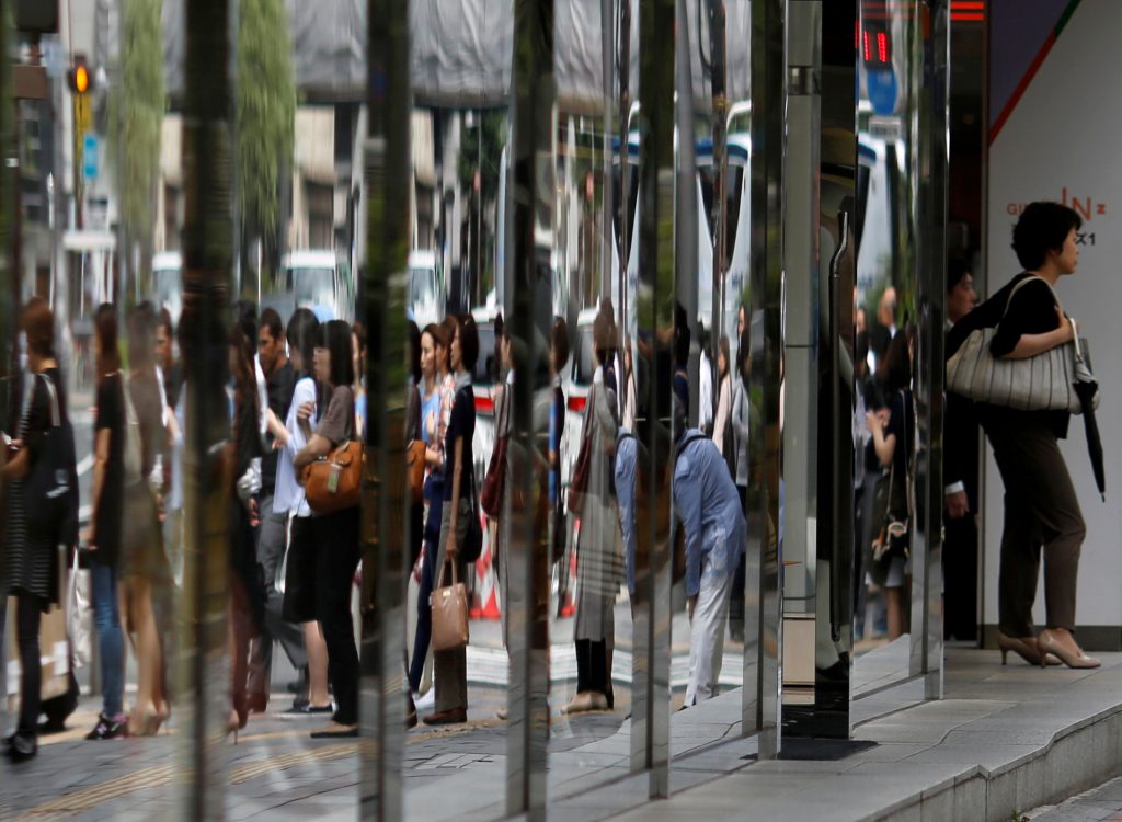 People are reflected in the windows of a department store in a shopping district in Tokyo, Japan June 29, 2016. (Reuters)