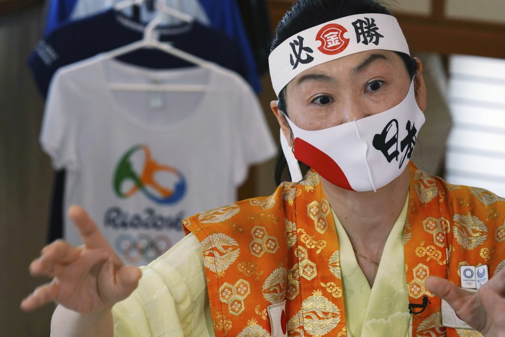 Olympic fan Kyoko Ishikawa speaks during an interview at home Saturday, April 10, 2021, in Tokyo. Ishikawa, president of an IT company, has attended every Summer Olympics since Barcelona in 1992, becoming famous as an unofficial 