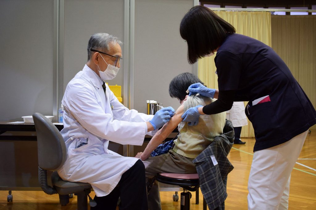 An elderly woman receives a dose of the COVID-19 vaccine in Okayama on April 12, 2021 as Japan begins vaccinating the elderly. (AFP via JIJI Press)
