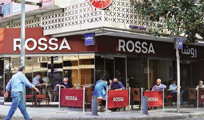 Patrons, mask-clad due to the COVID-19 coronavirus pandemic, sit at a cafe in the Hamra neighborhood of Lebanon’s capital Beirut. (File/AFP)