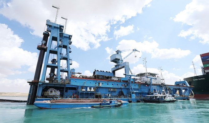 A file photo shows a dredger trying to free the Panama-flagged MV Ever Given long vessel across the waterway of Egypt's Suez Canal. (AFP)