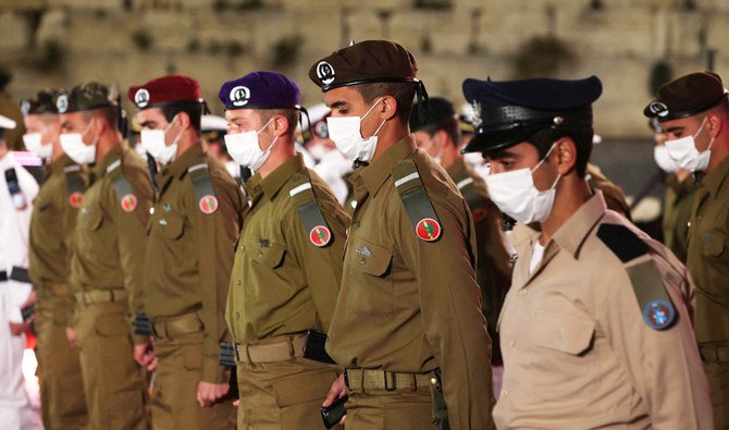 An honour guard of Israeli soldiers with their rifles stands to attention during a one minute siren, as they partake in a state ceremony for Memorial Day in Jerusalem on April 13, 2021. (AFP)