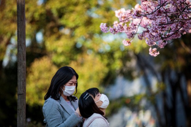 People look at the cherry blossoms at Ueno park in the Japanese capital Tokyo on March 19, 2020. (Photo by Behrouz Mehri / AFP)